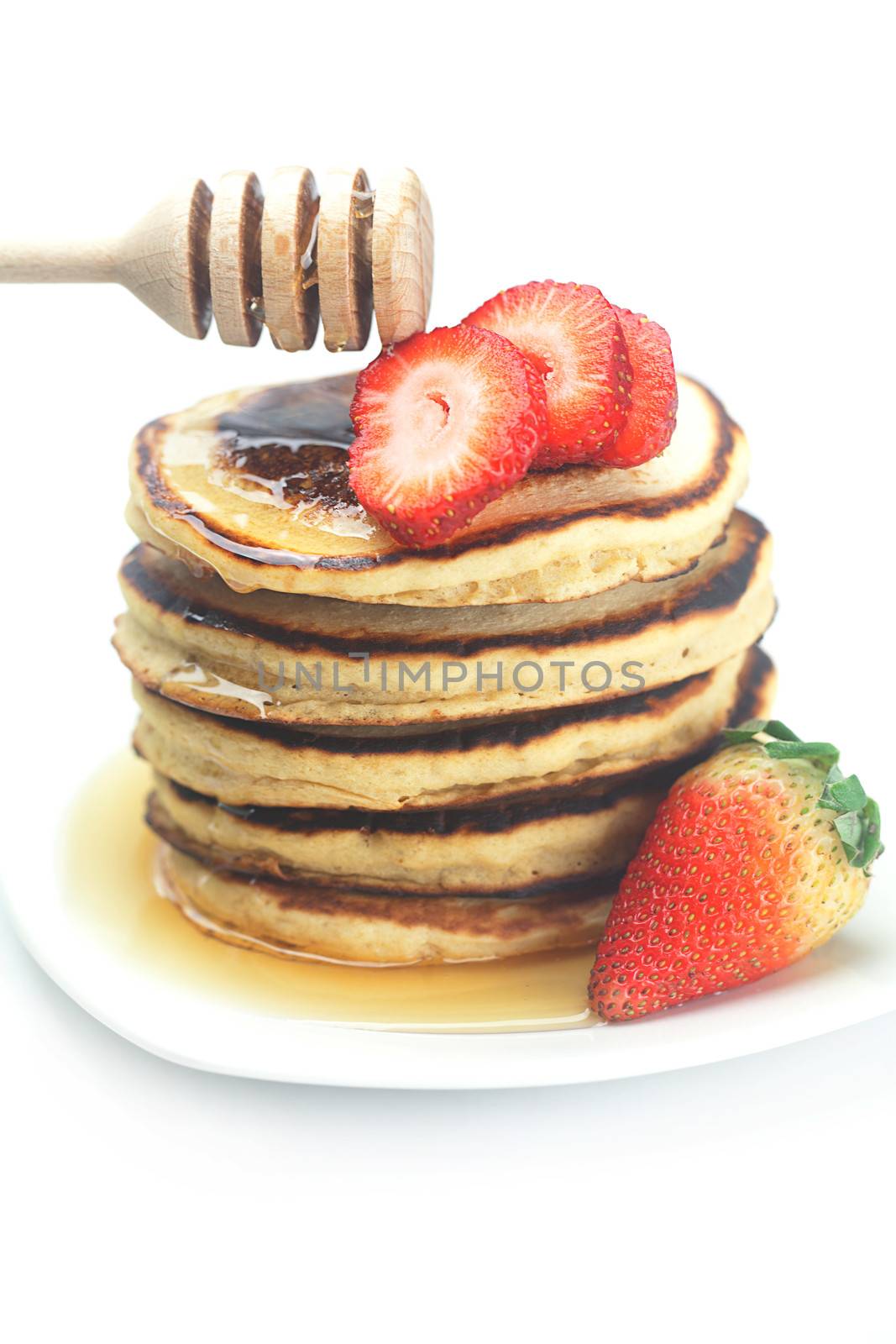 Pancakes, honey, strawberry and stick to honey isolated on white by jannyjus