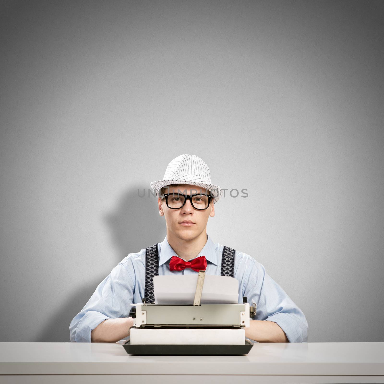 image of a young journalist, sitting at the table for a typewriter