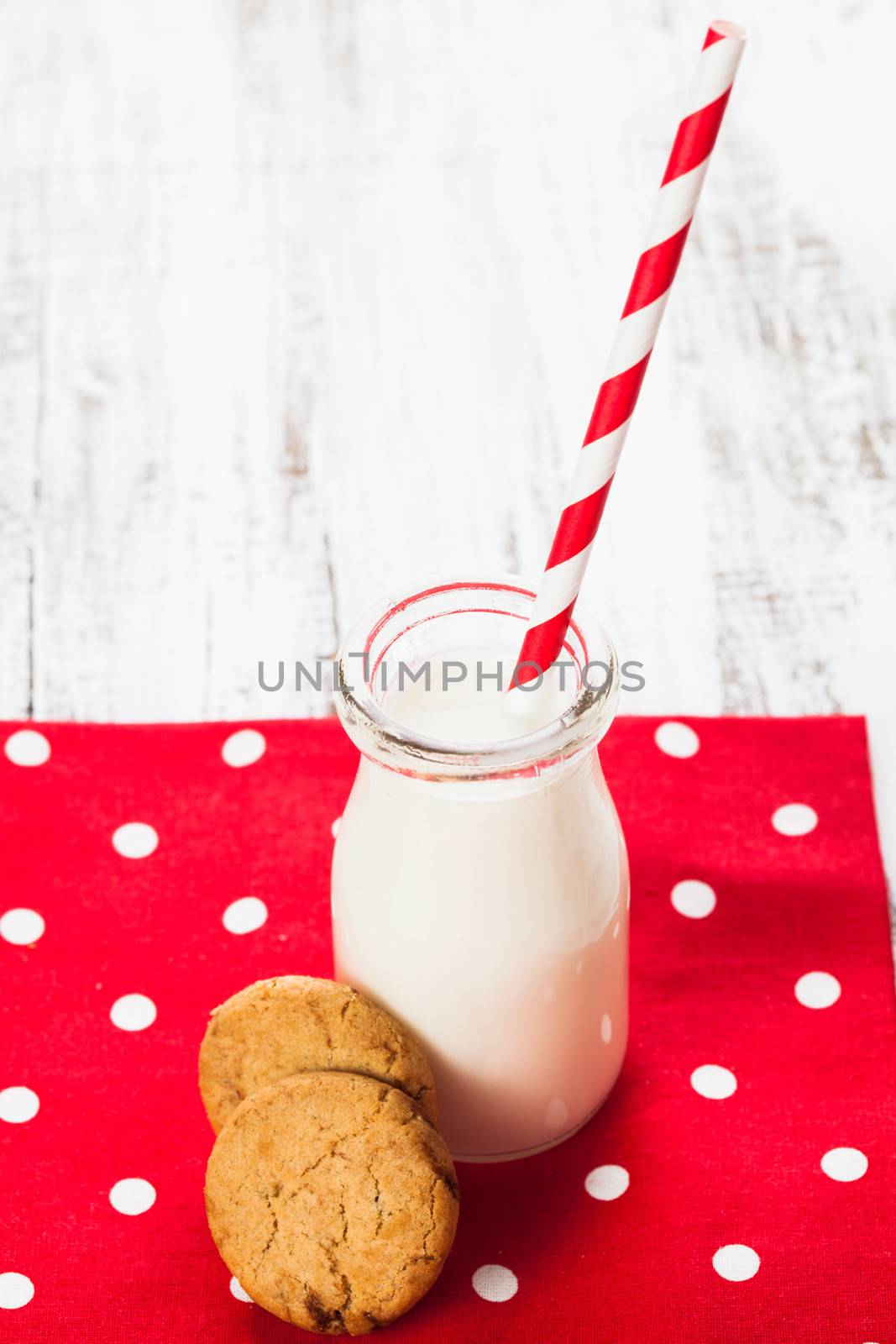 Milk in bottle with paper straw with cookies