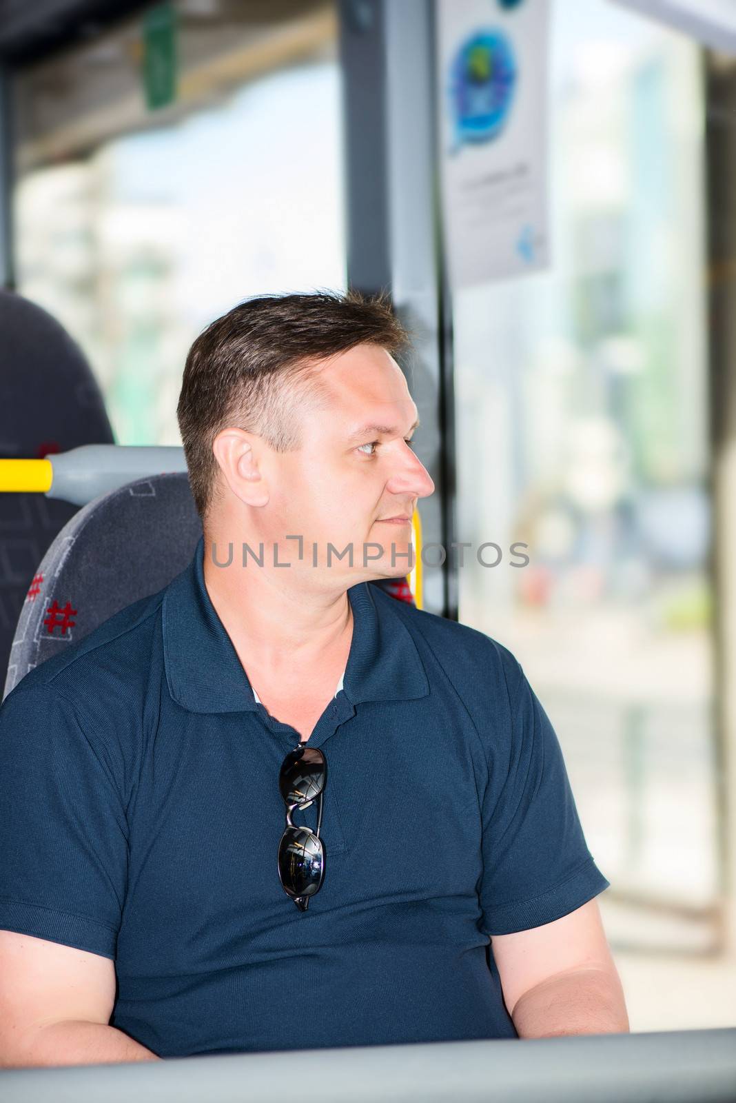 man traveling by bus and looking away in window