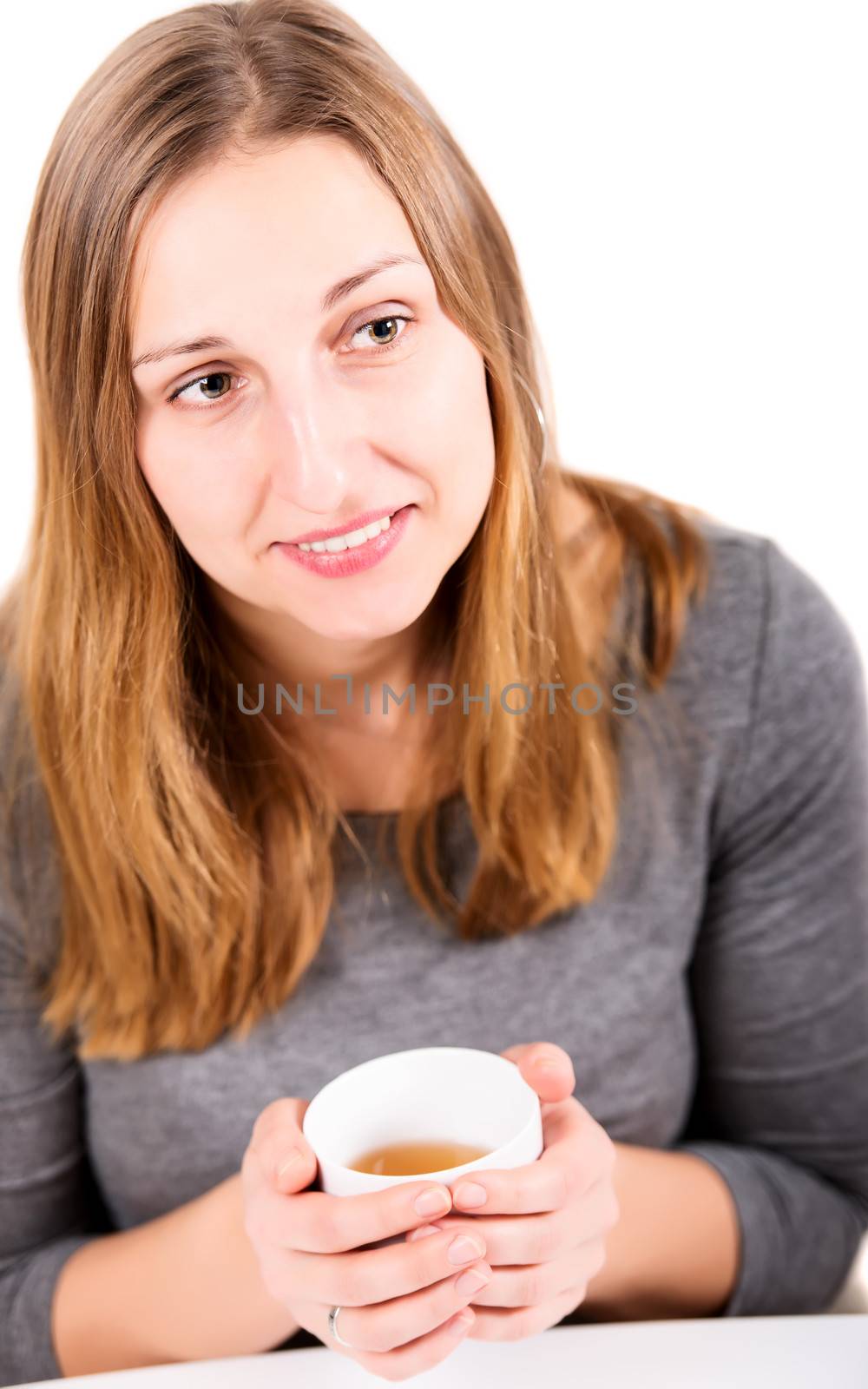 Happy girl in grey holding mug and not looking at camera with smile