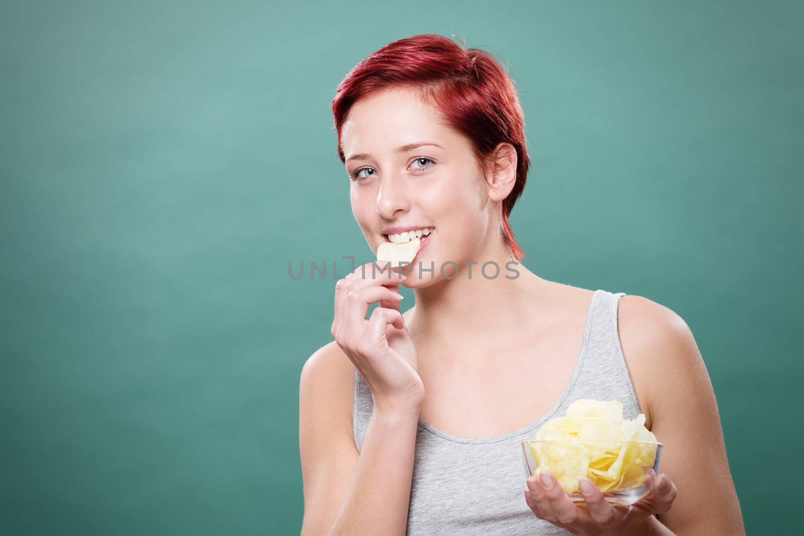 happy redhead woman eating potato chips