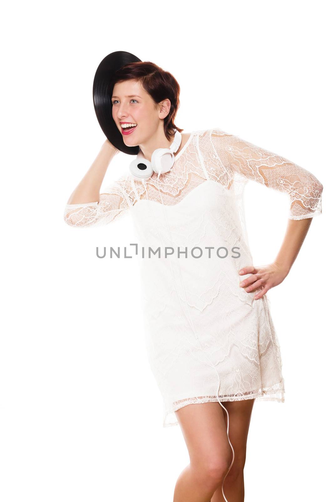 happy woman in white dress listening funny to a record on white background