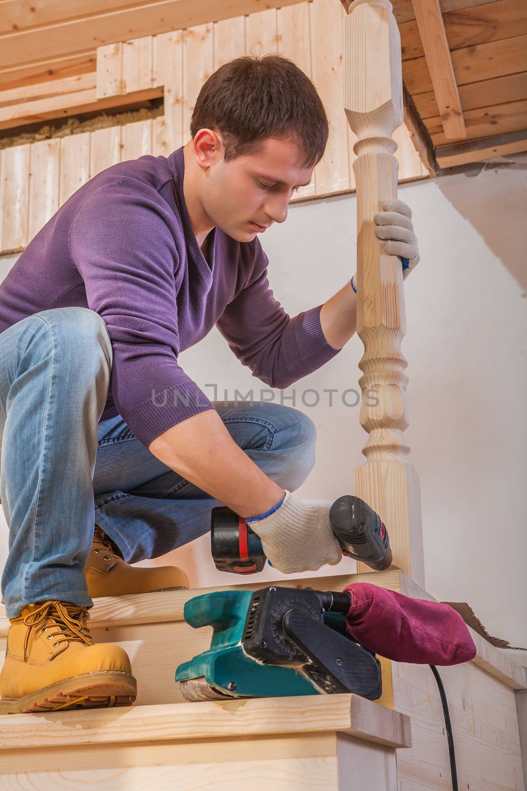 a young carpenter fixing post of ladder