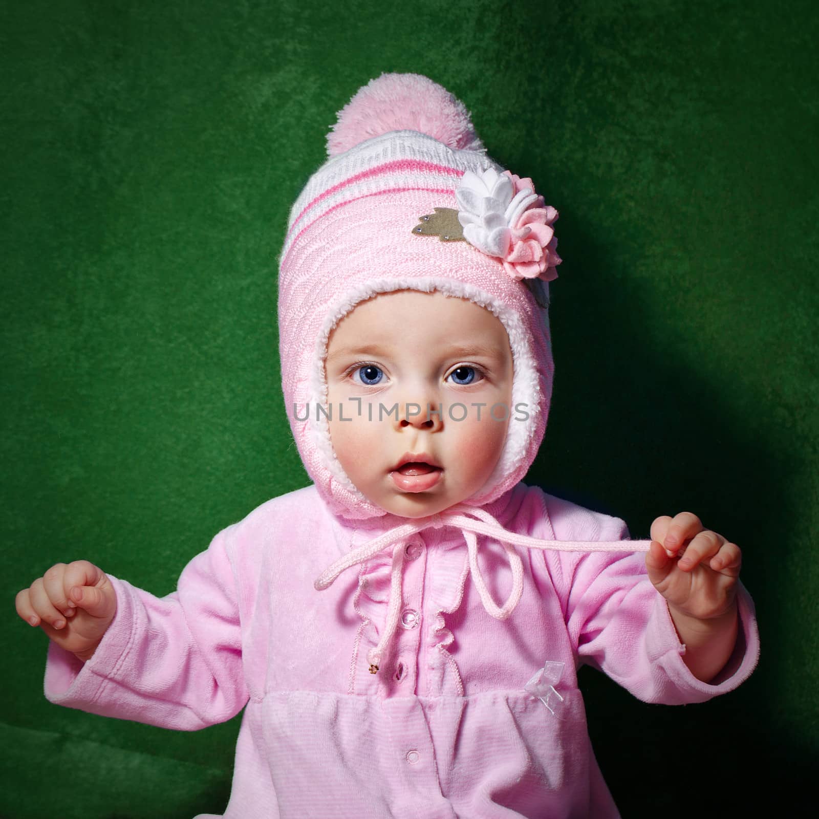 Cute little girl with blue eyes wearing pink hat