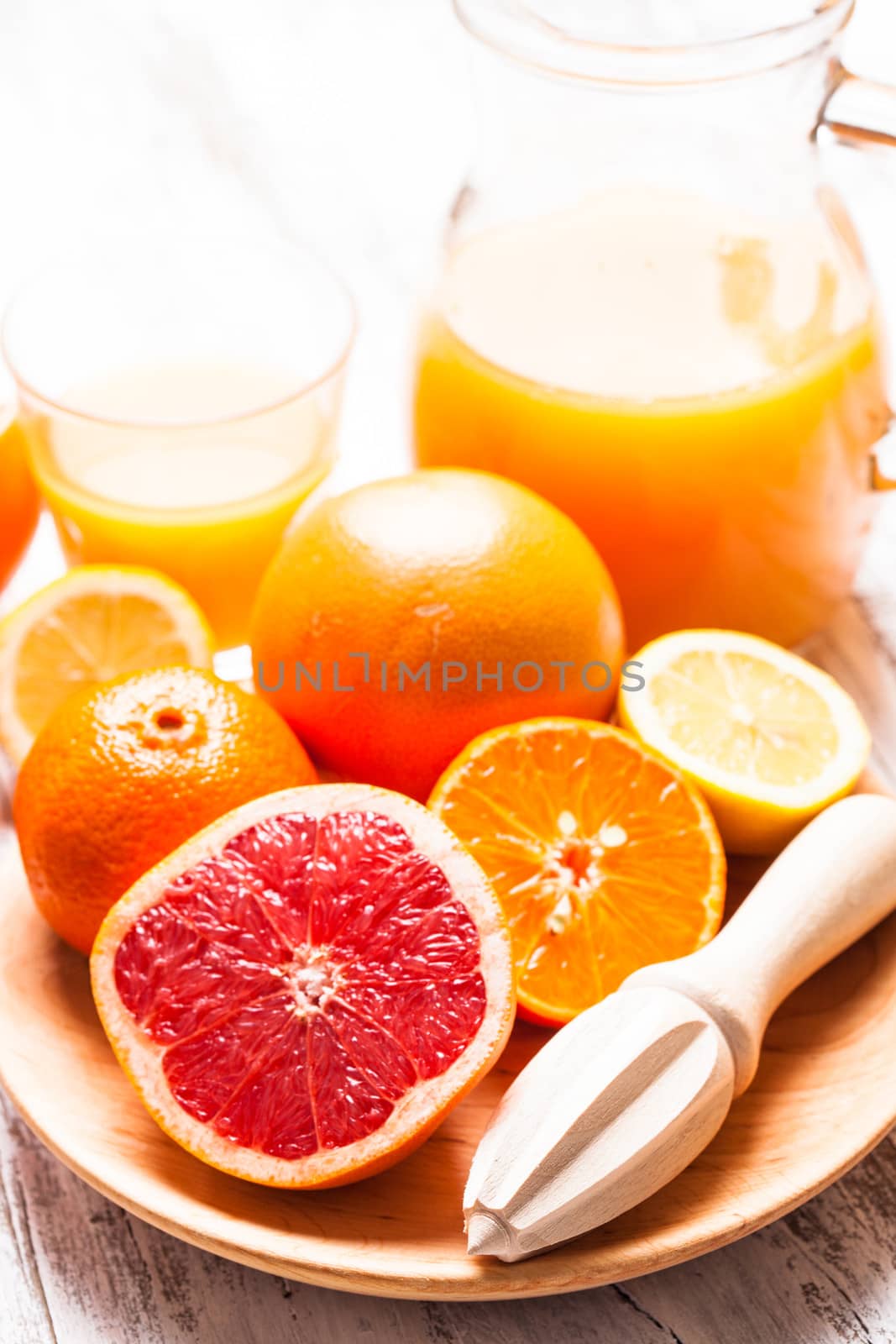 The preparation for citrus juice for breakfast. Wooden  citrus reamer with fruits.