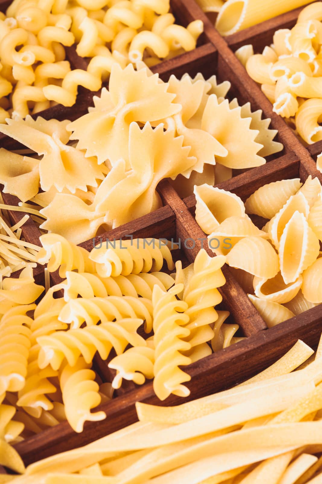 Various pasta  types in the wooden box on the table