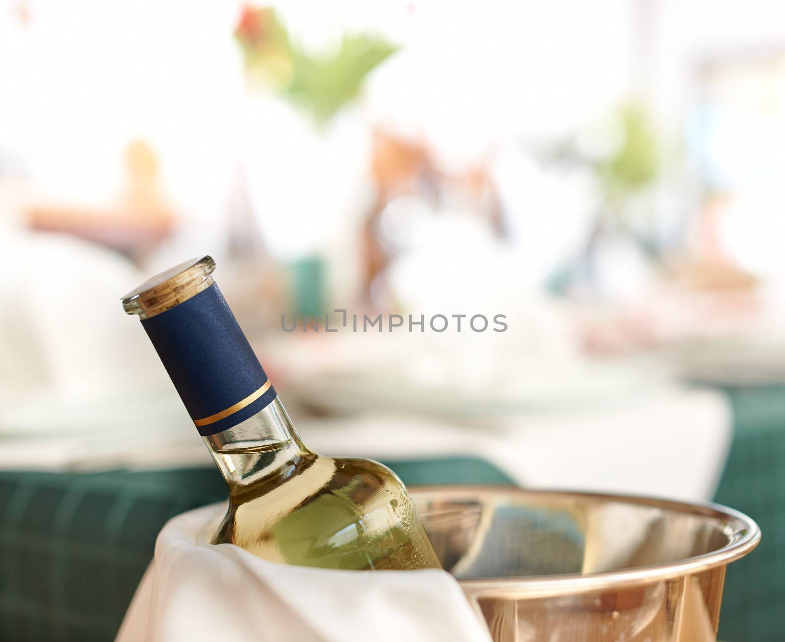 Bottle of cold white wine in ice on restaurant table