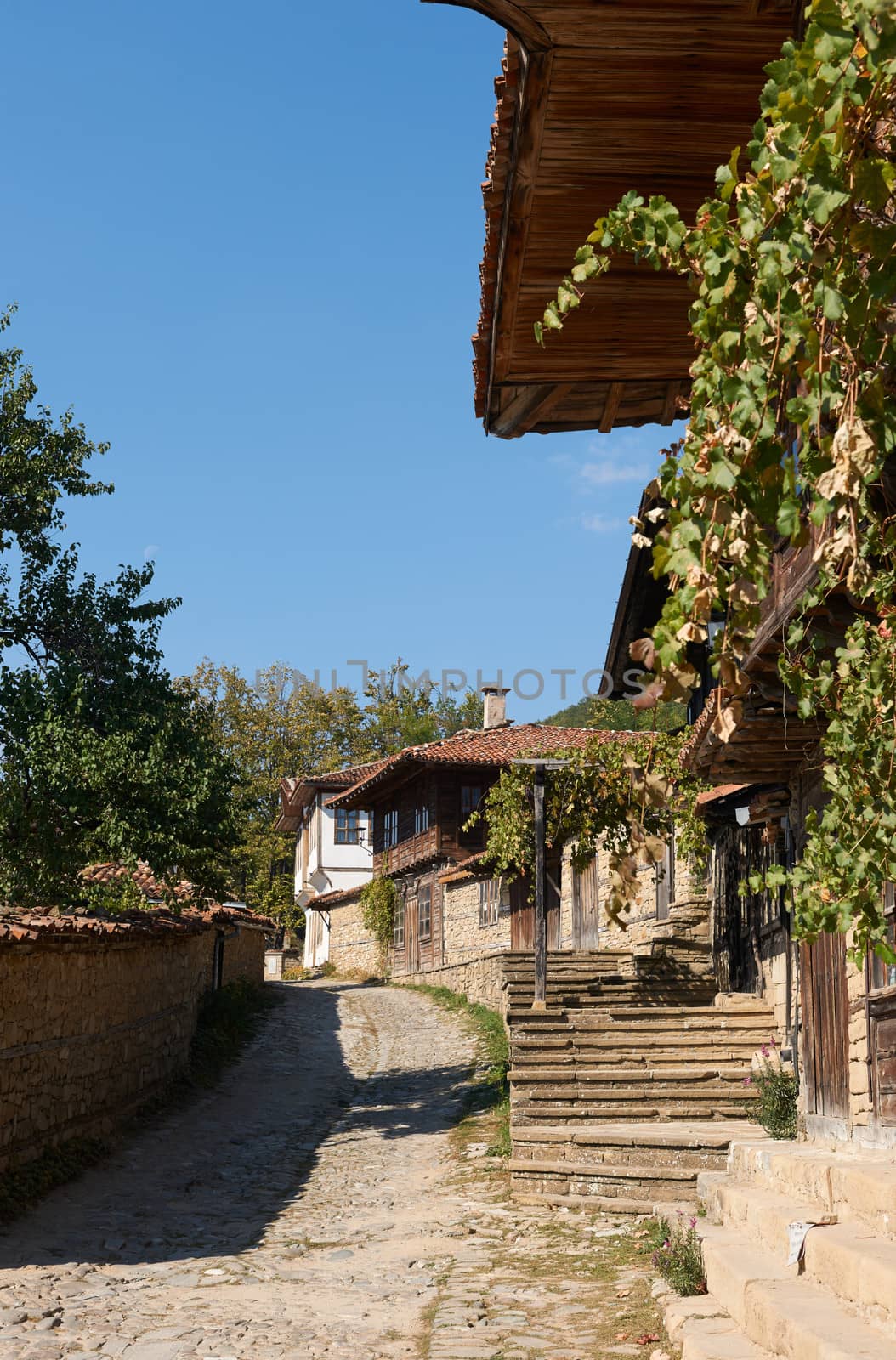 Summer street in Bulgarian revival village Zheravna with wooden houses amd stone-paved street