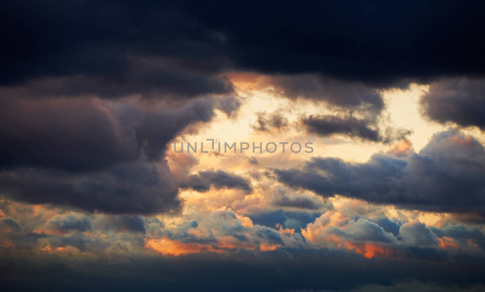 Colorful sunset dark storm clouds after rain storm