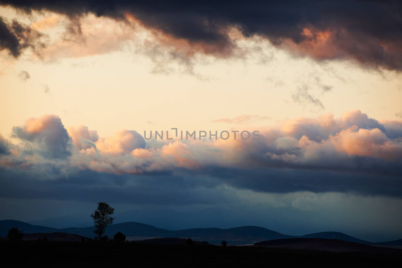 Sunset landscape with dark storm clouds after autumn rain