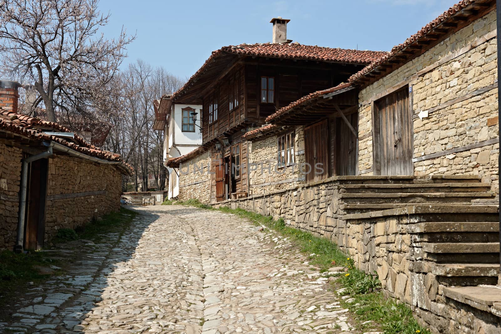 Stone paved street in spring season Zheravna village, Bulgaria with beautiful wooden houses