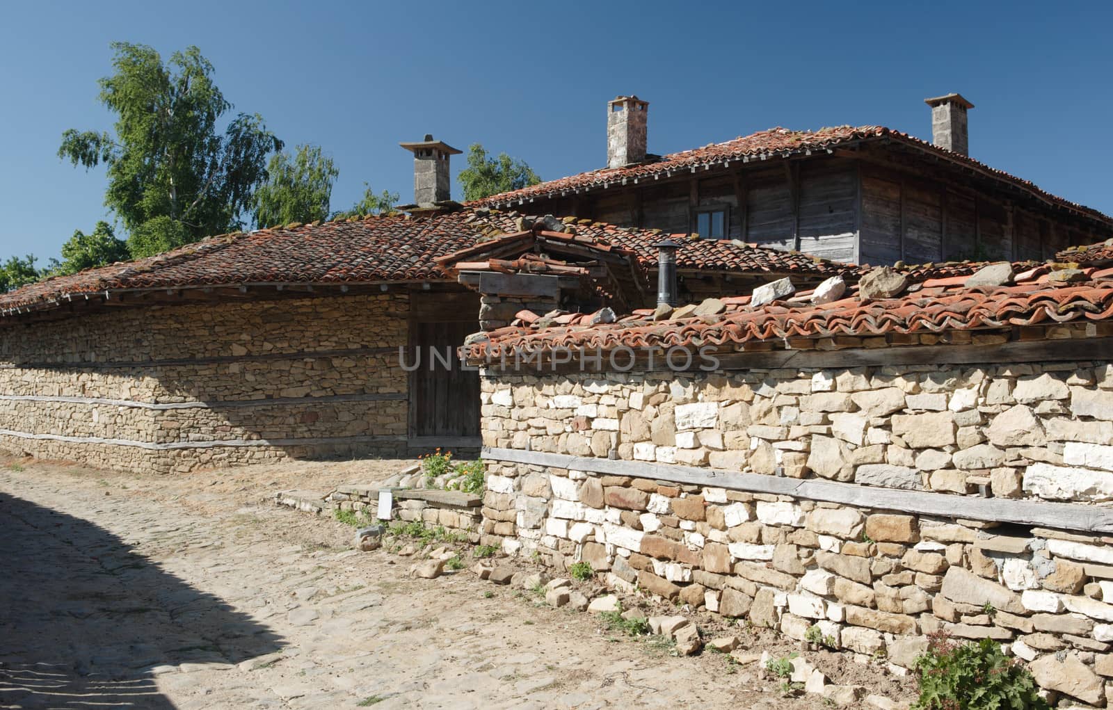 Street with old house and stone fences in Zheravna village, Bulgaria