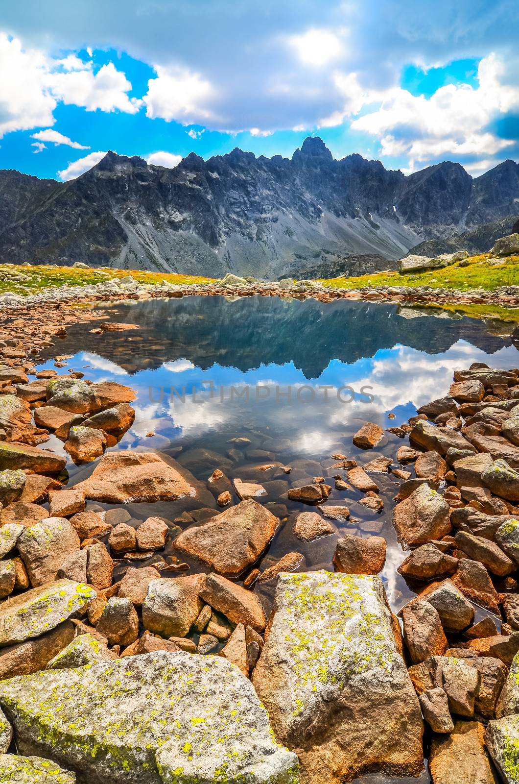 scenic vertical view of a mountain lake and rocks in High Tatras, Slovakia