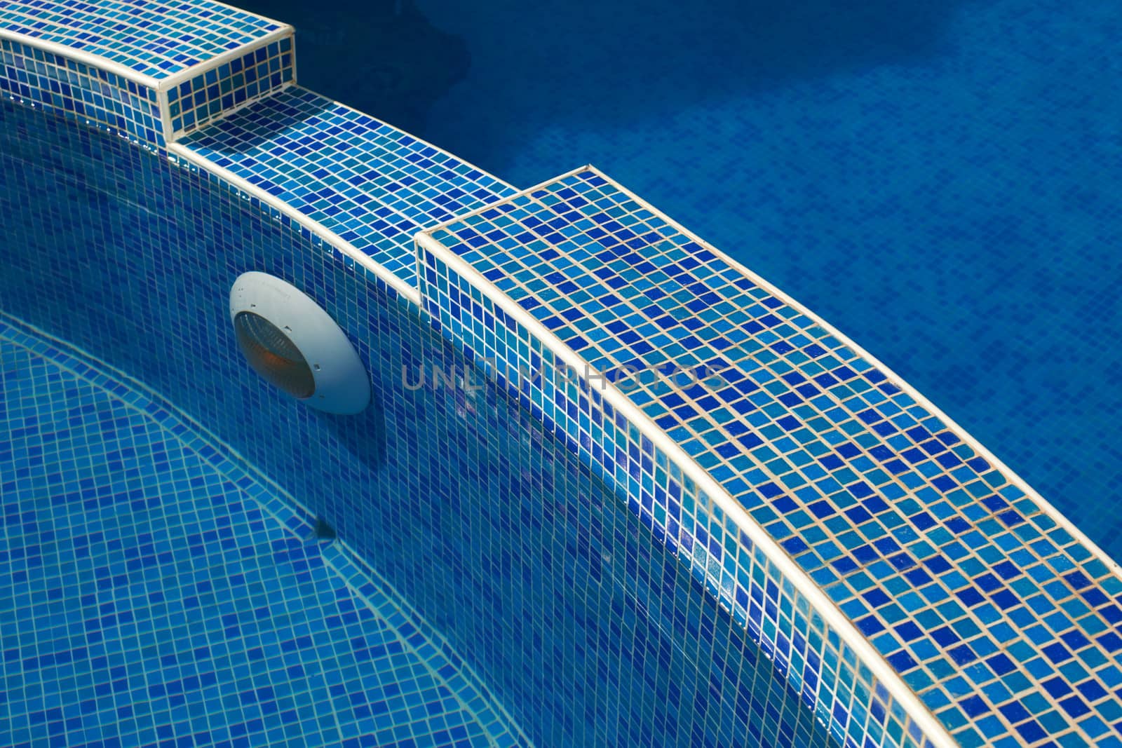 Blue water in a pool with tiles