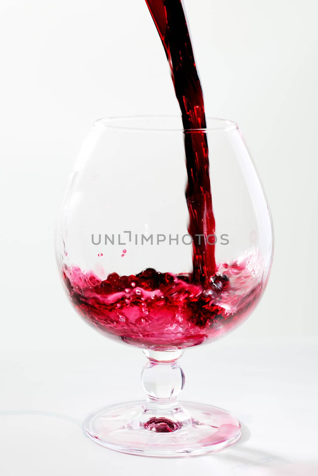 Filling a wide glas with red wine