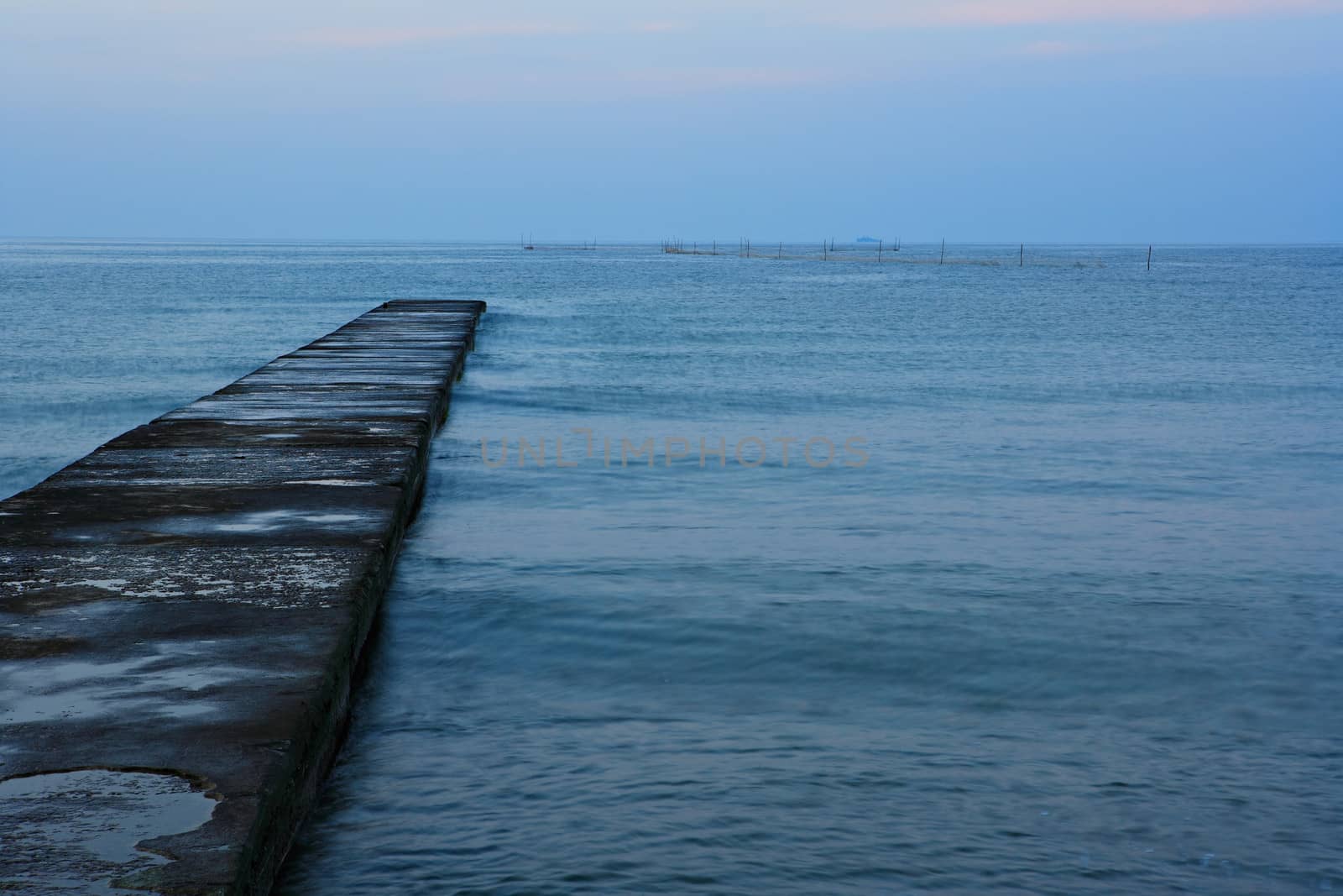 Old quay in a morning blue sea water