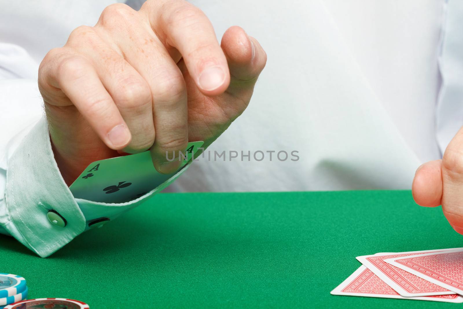 gambler. Male hand with cards and chips on green table