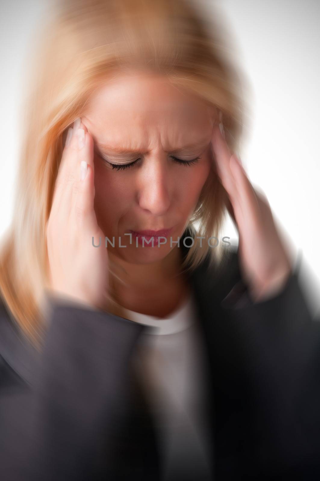 Business woman suffering from an headache, holding her hands to the head, with radial blur effect applied
