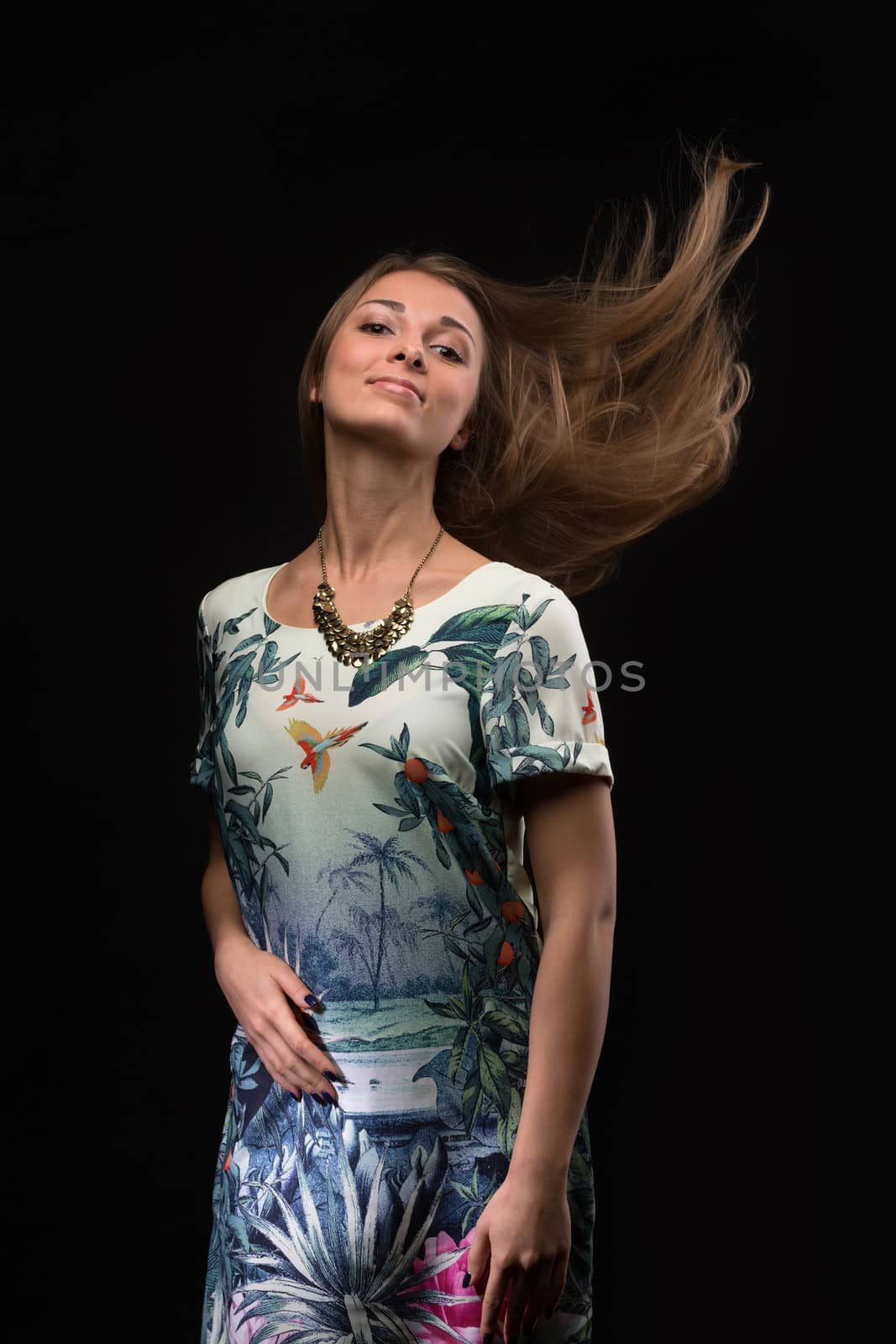 Portrait of the girl with fluttering hair. Studio photography.