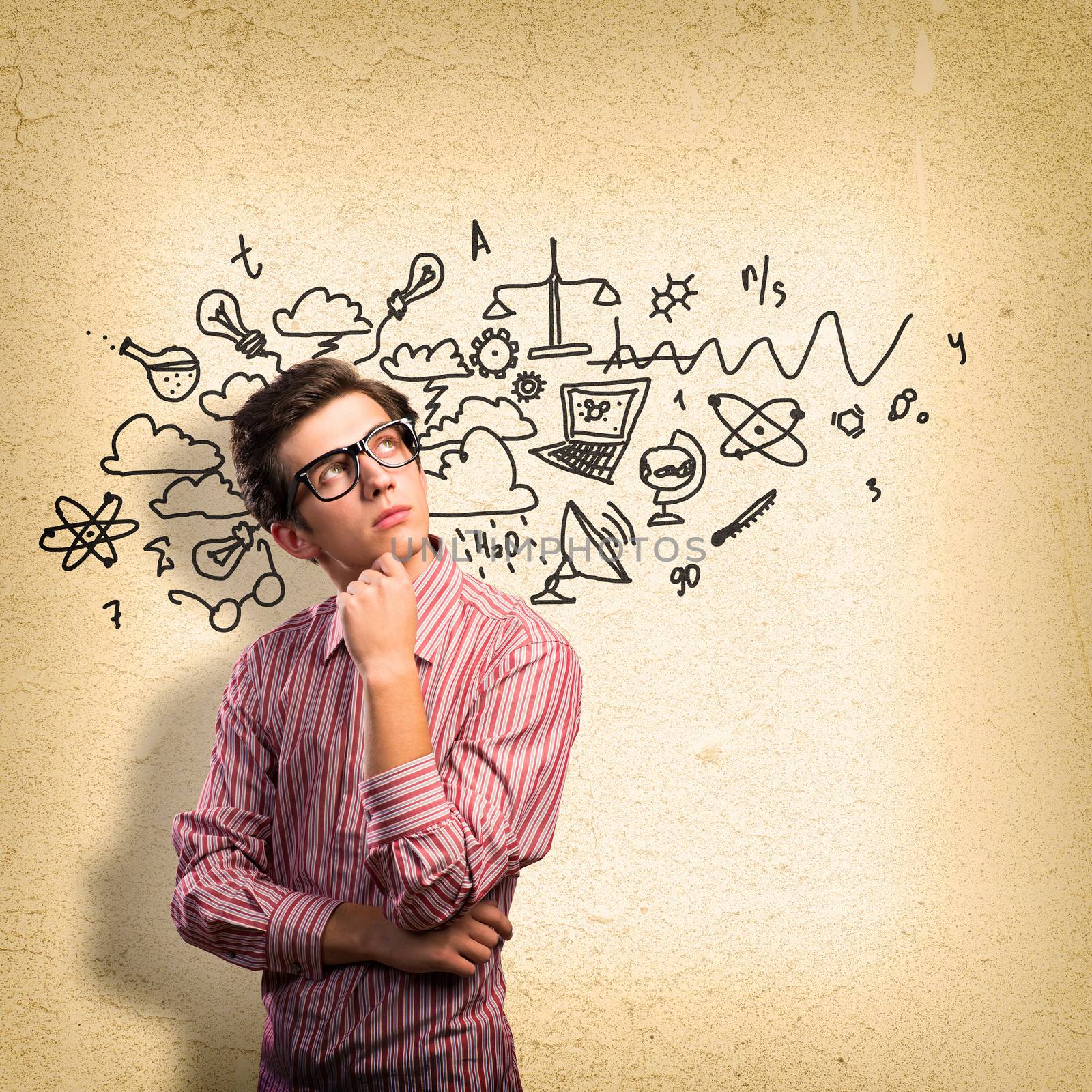 young man scientist in glasses thinking. next to it various painted symbols