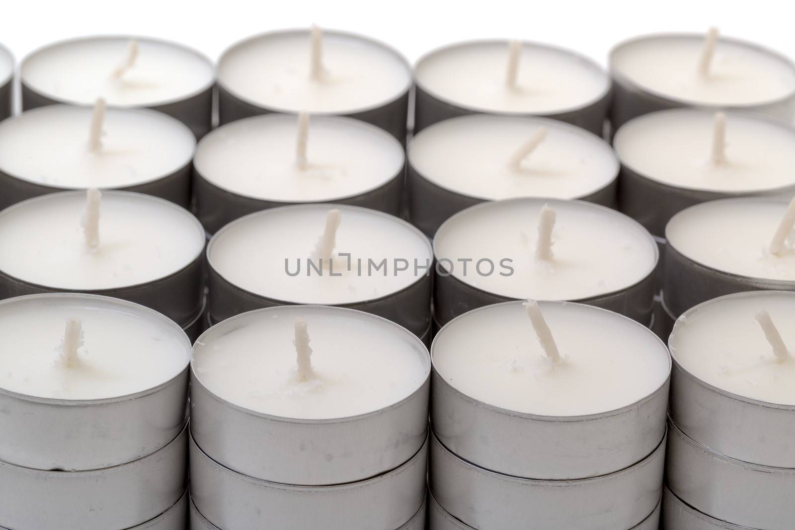 High angle view of rows of white wax tea light candles