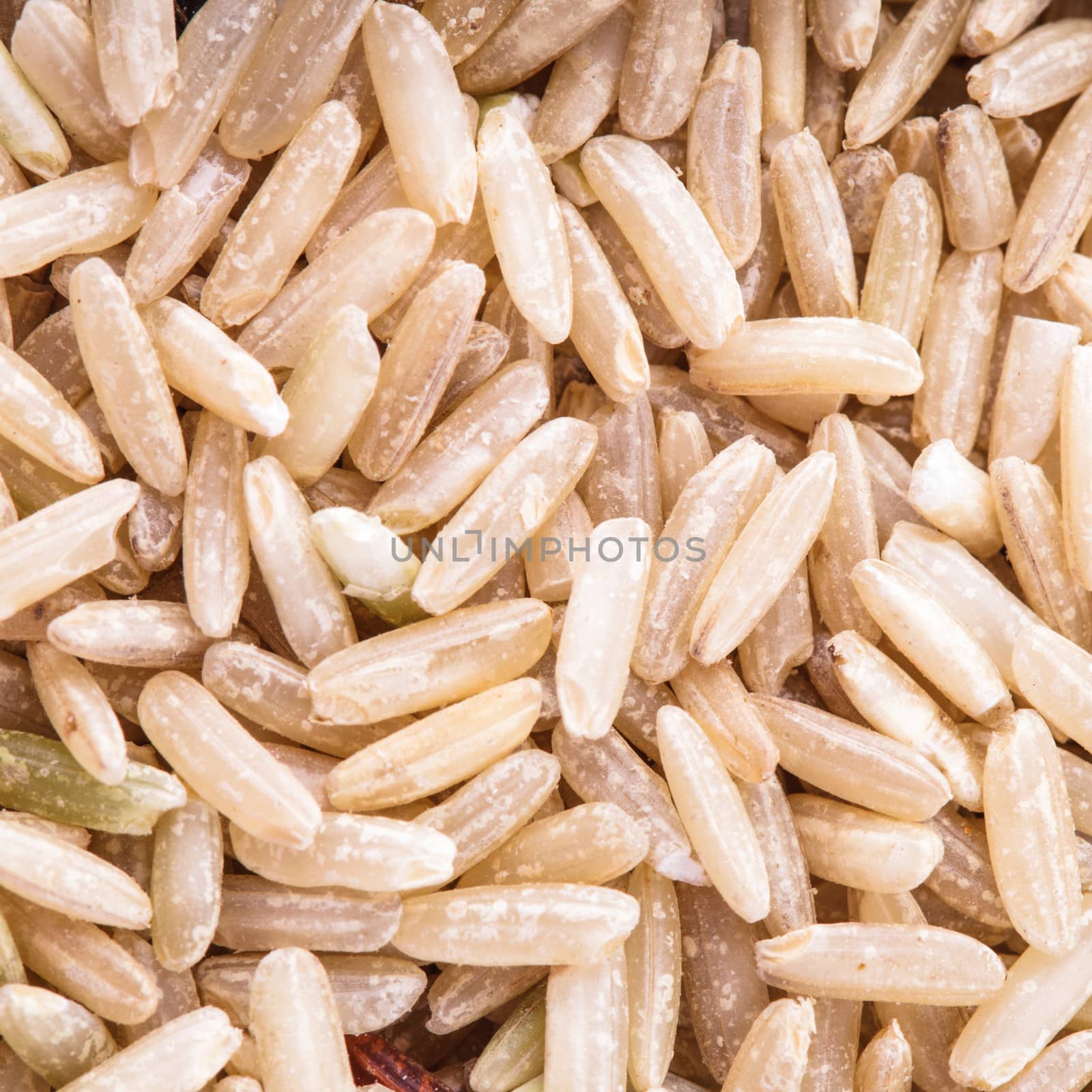 Brown rice scattered as a background. Food design.