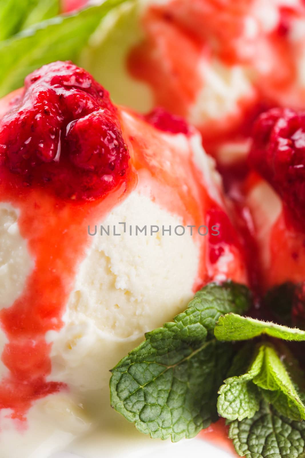 Vanilla ice cream with strawberry jam and mint leaves