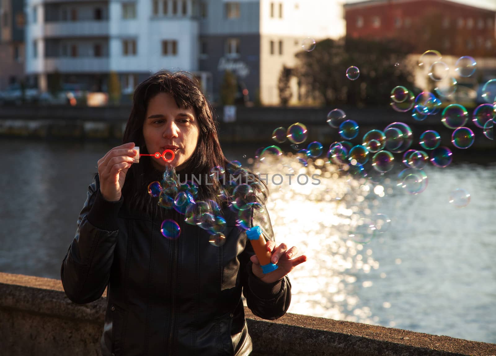 young beautiful woman blows bubbles outdoor