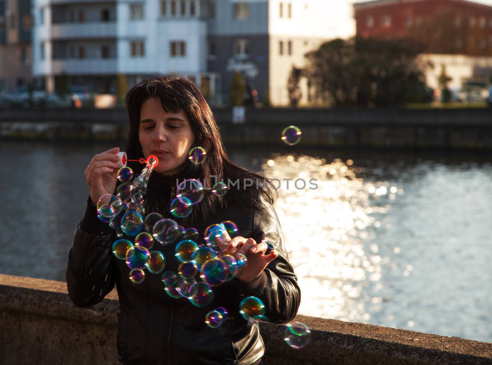 young beautiful woman blows bubbles outdoor