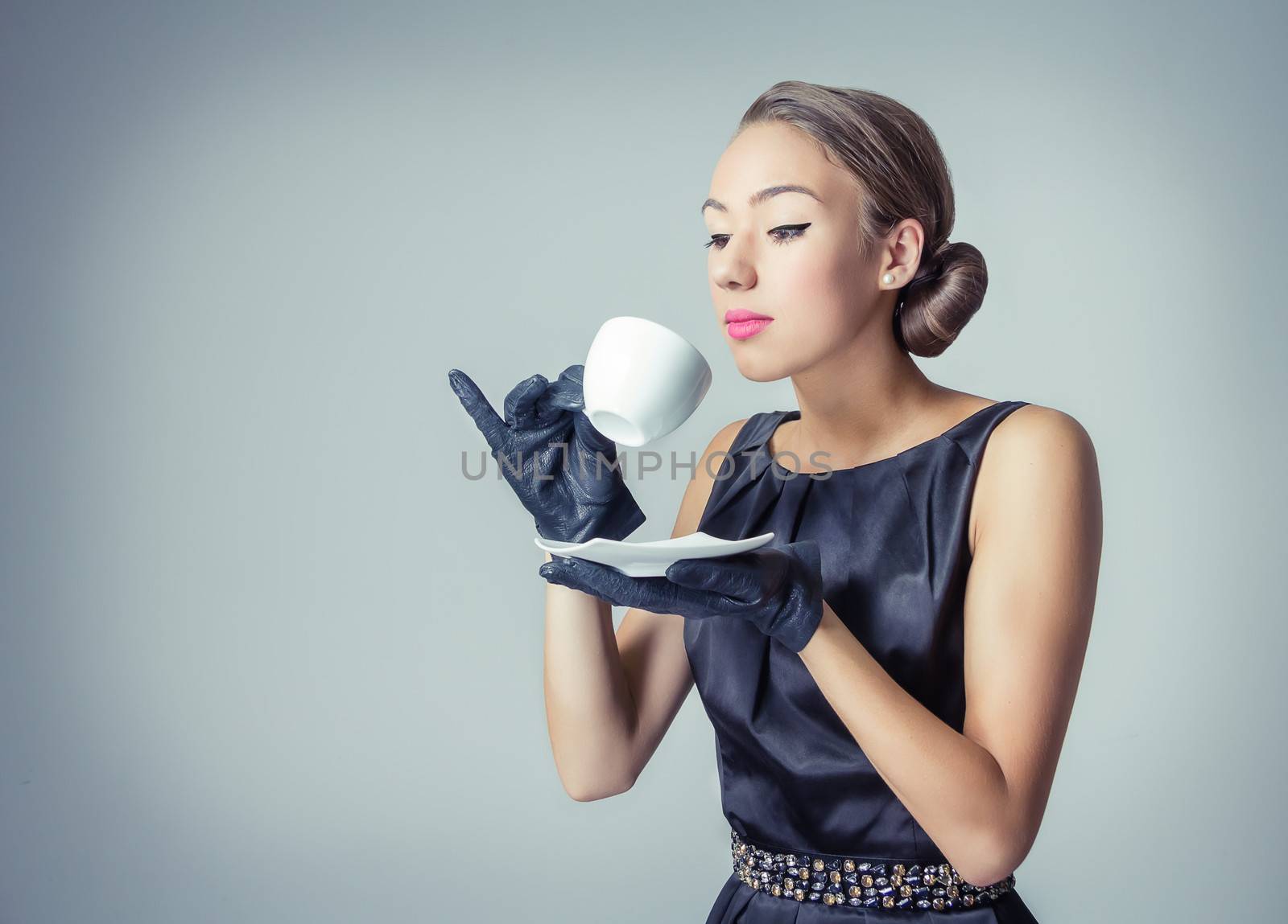 Fashion portrait of beautiful young girl with a coffee cup in classic vintage style