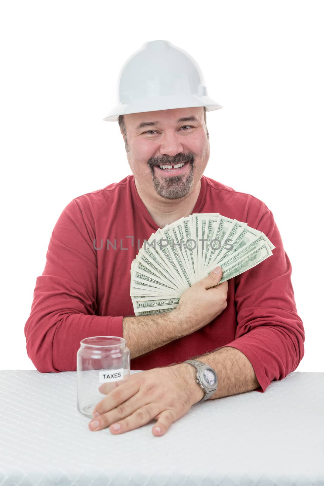 Happy construction worker wearing a hard-hat holding-on to dollar notes destined to taxes
