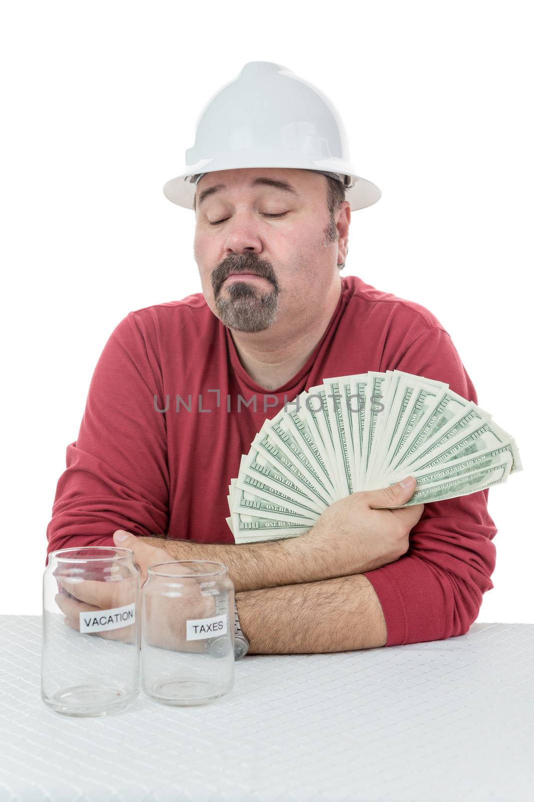Construction worker deciding if the money will be used to pay tax obligations or used for personal vacations