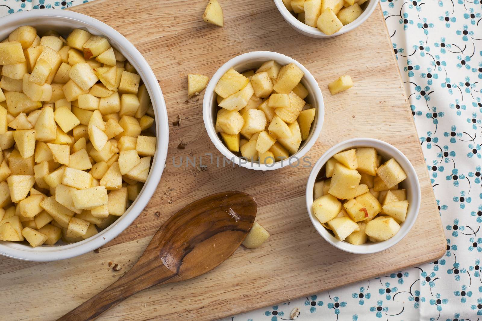 Chopped apples with sugar and spices in baking dishes.