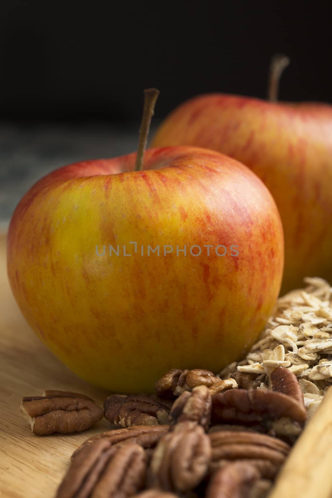 Red and yellow apples with pecans, ingredients for an apple crumble.