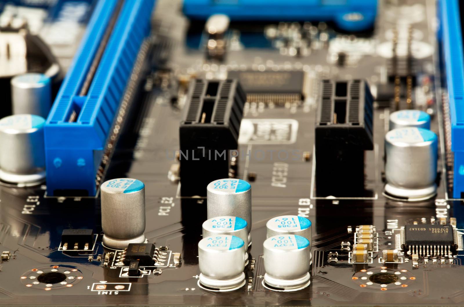 Condensators on laptop motherboard close view by RawGroup