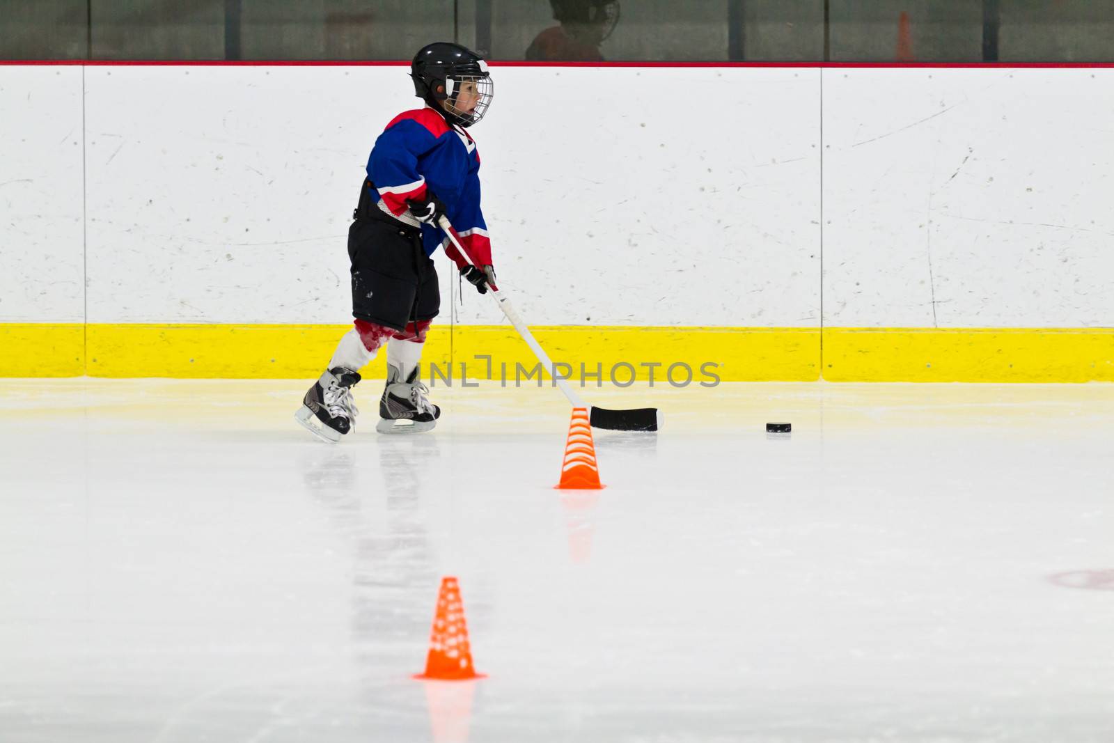 Child practices stickhandling at ice hockey practice by bigjohn36