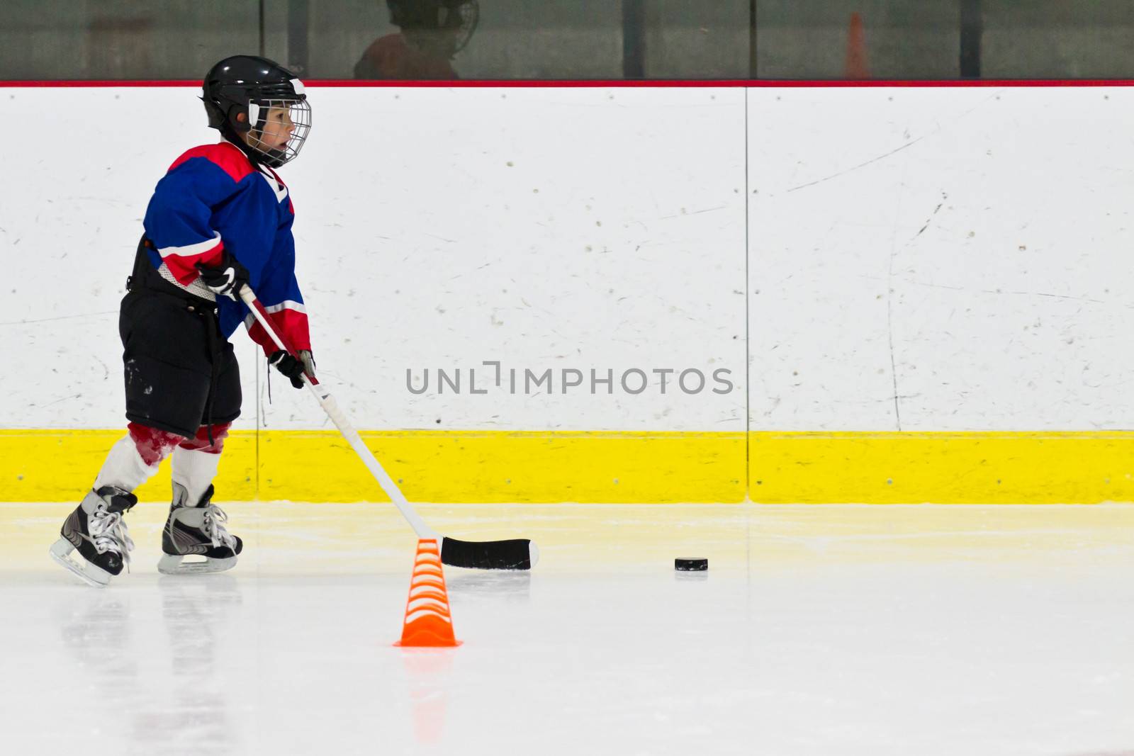 Child practices stickhandling at ice hockey practice by bigjohn36