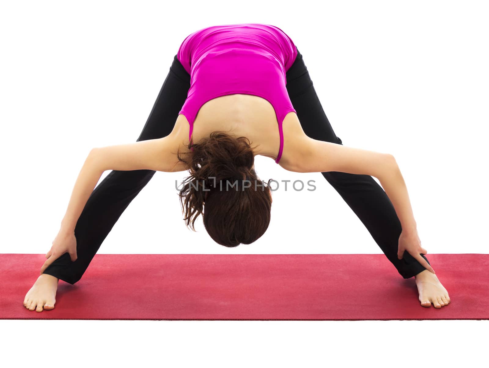 Woman doing a variation of wide legged forward bend in yoga (Series with the same model available)