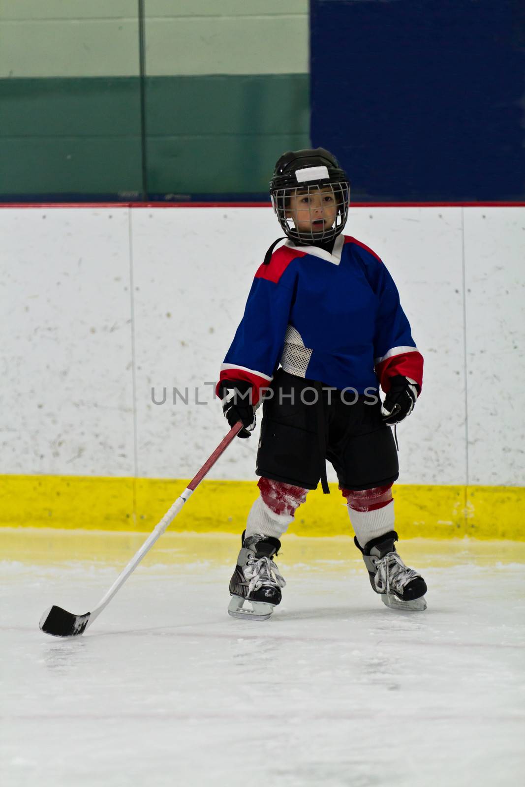 Young hockey player in an arena by bigjohn36