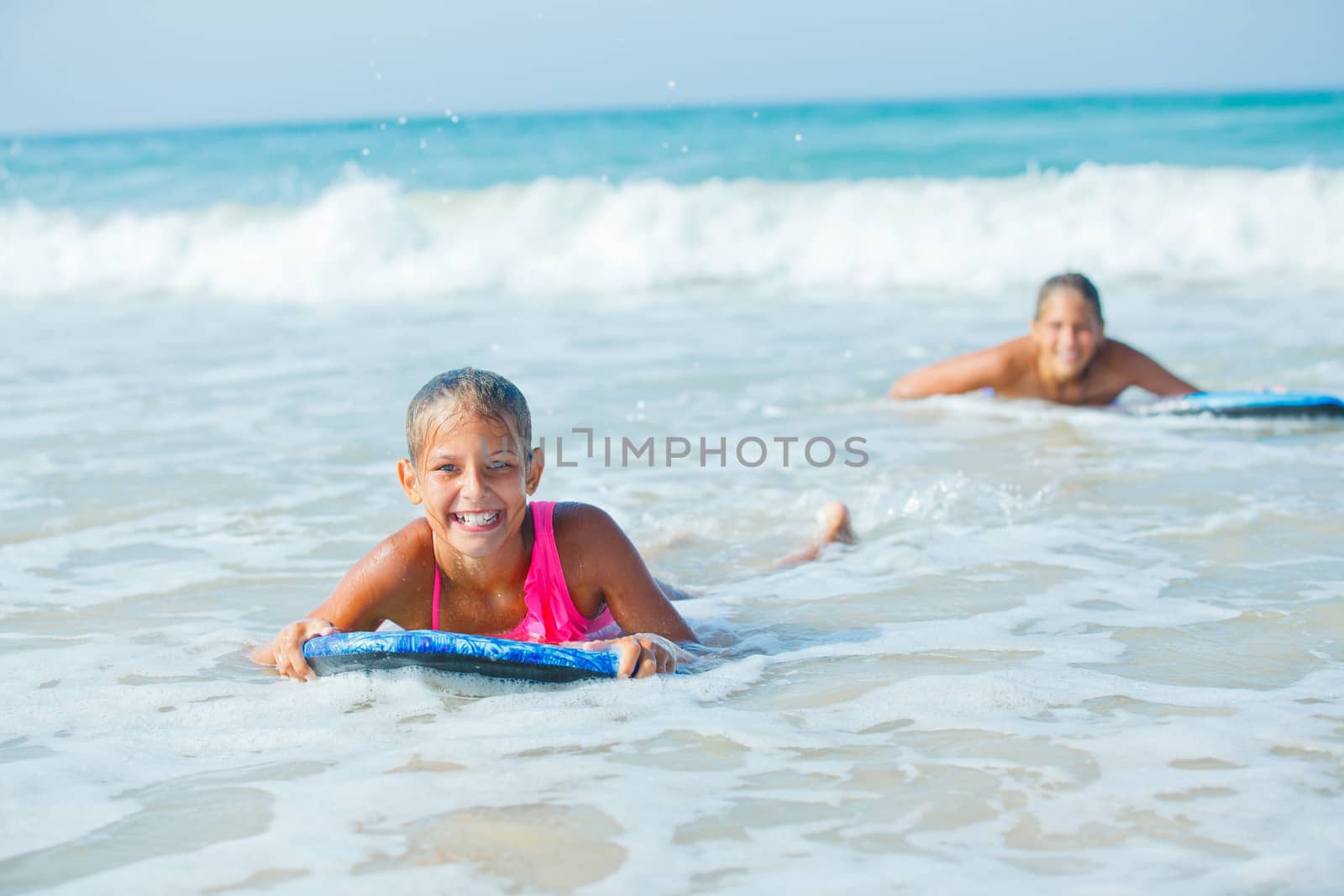 Summer vacation - Happy cute girl having fun with surfboard in the ocean