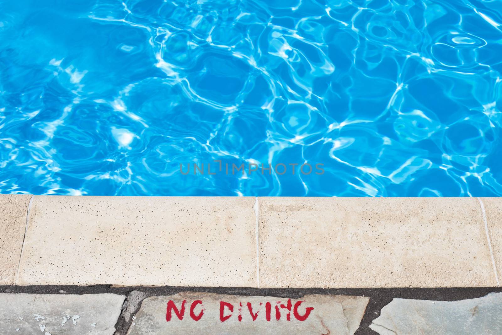 No diving warning at the edge of a swimming pool