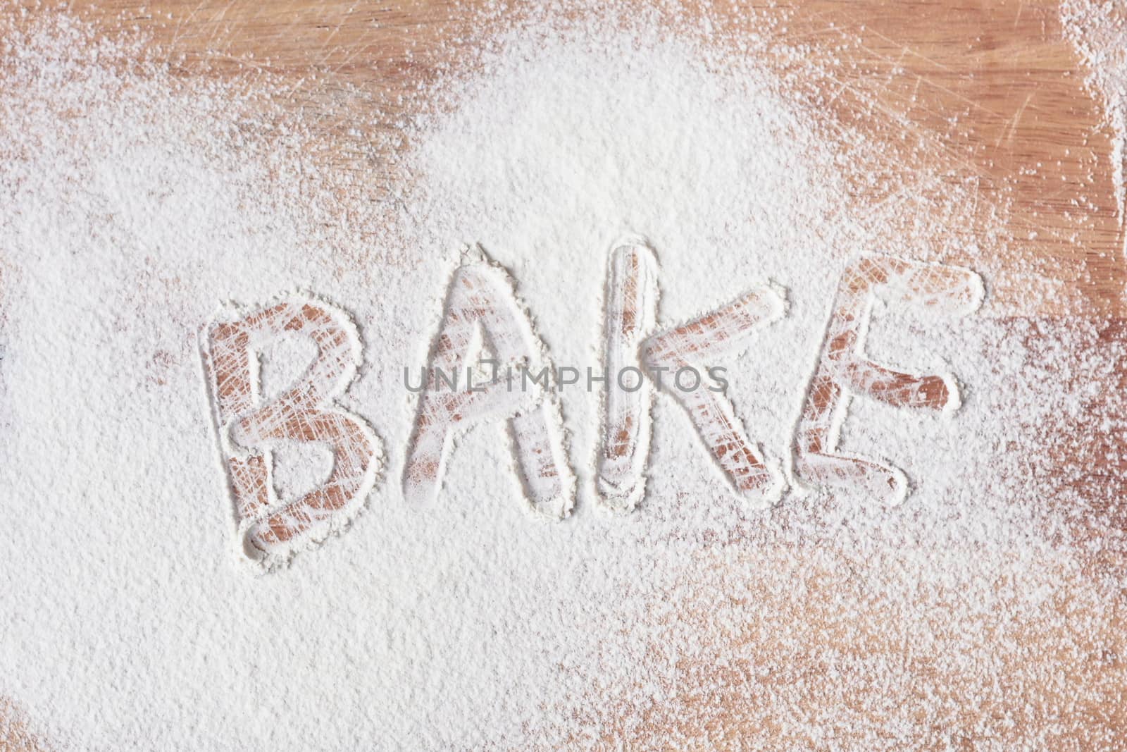 Bake written in flour on a wooden surface