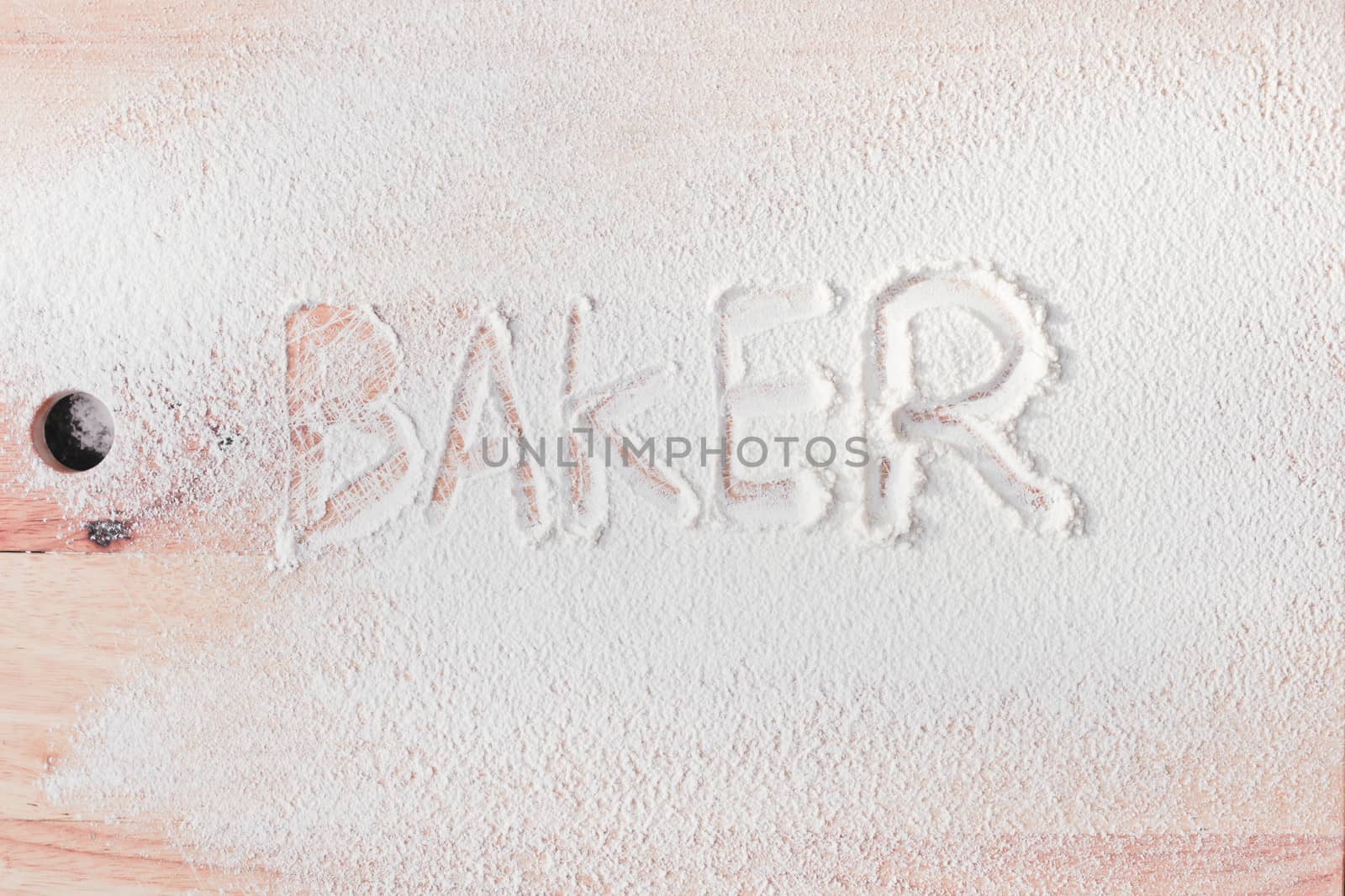 Baker written in flour on a wooden surface