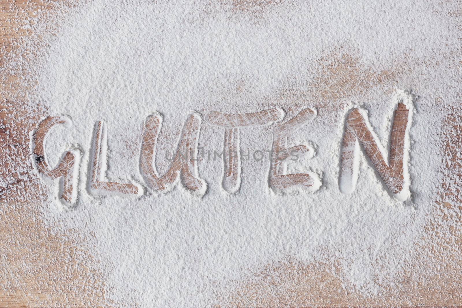 Gluten written in flour on a wooden surface