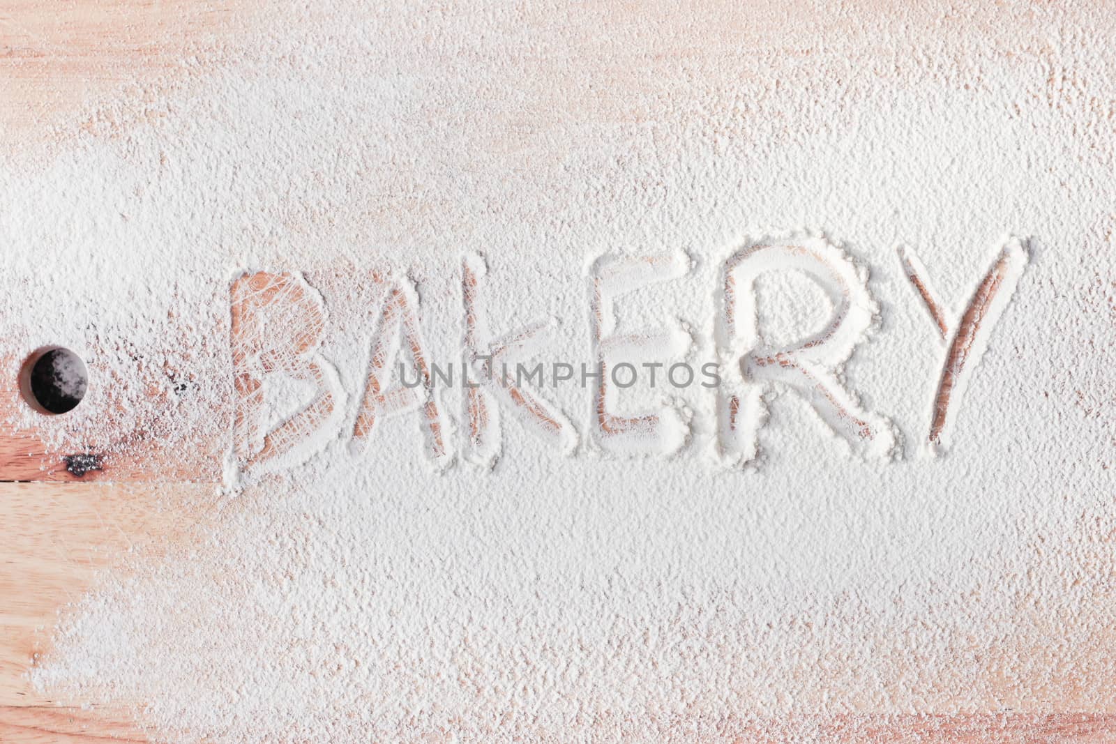 Bakery written in flour on a wooden surface
