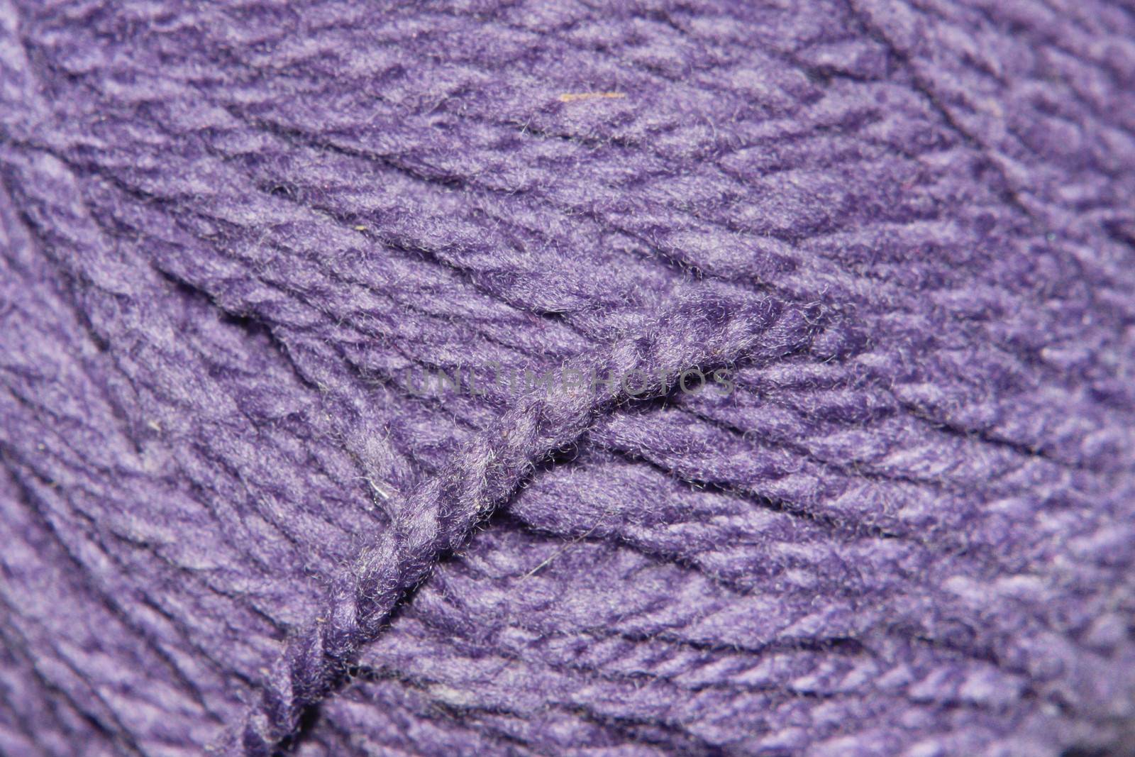 Purple wool close up showing thread with shallow depth of field