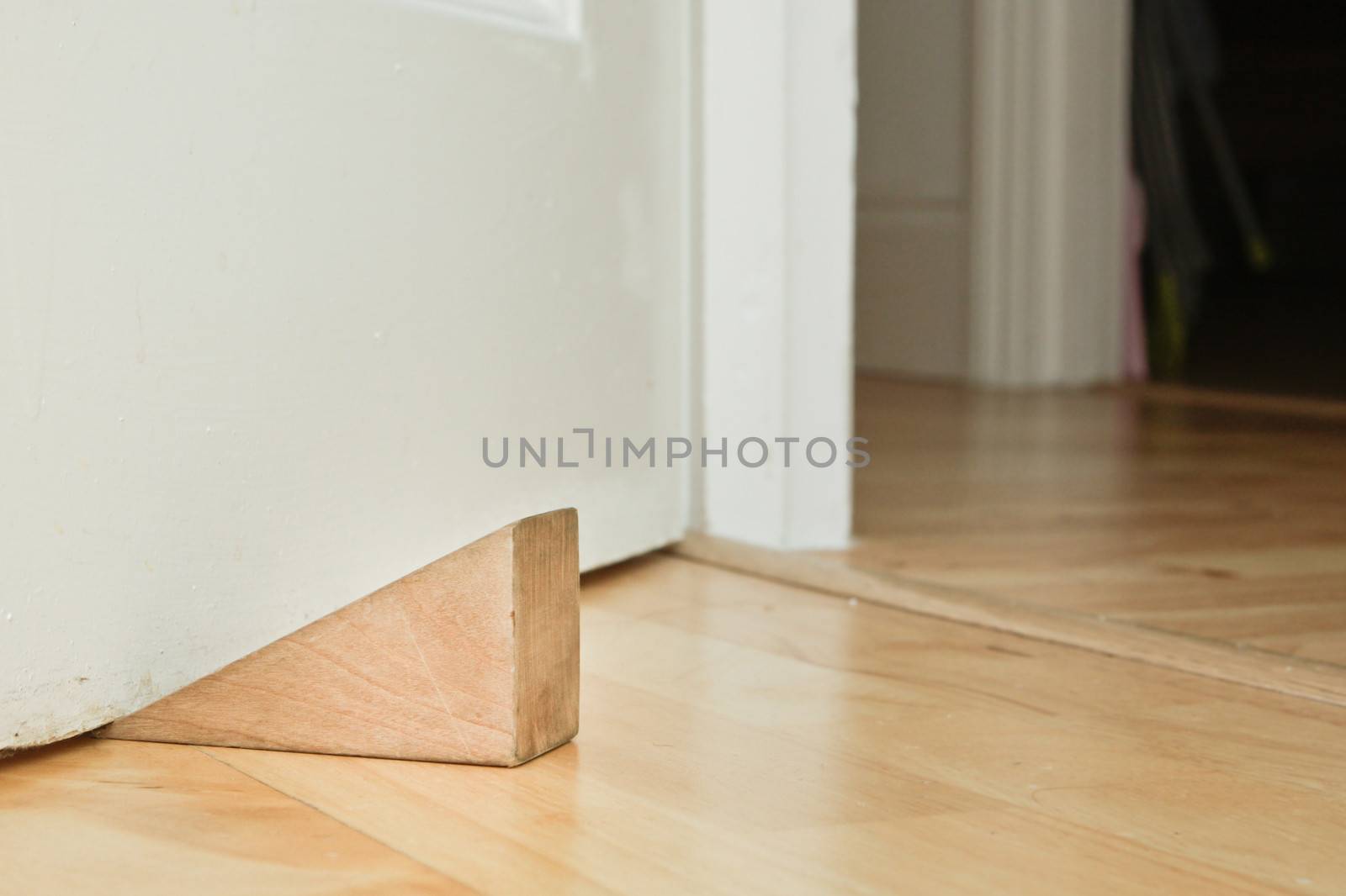 A wooden door stopper on a laminate floor