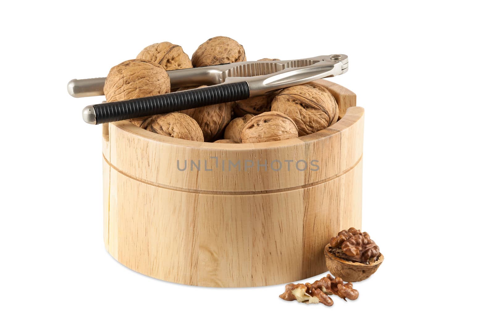 Walnuts in utensil with nutcracker isolated on white background with clipping path