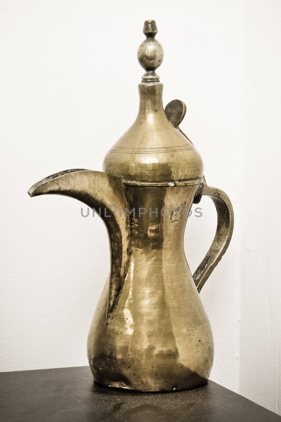 A traditional Omani brass coffee pot on a shelf